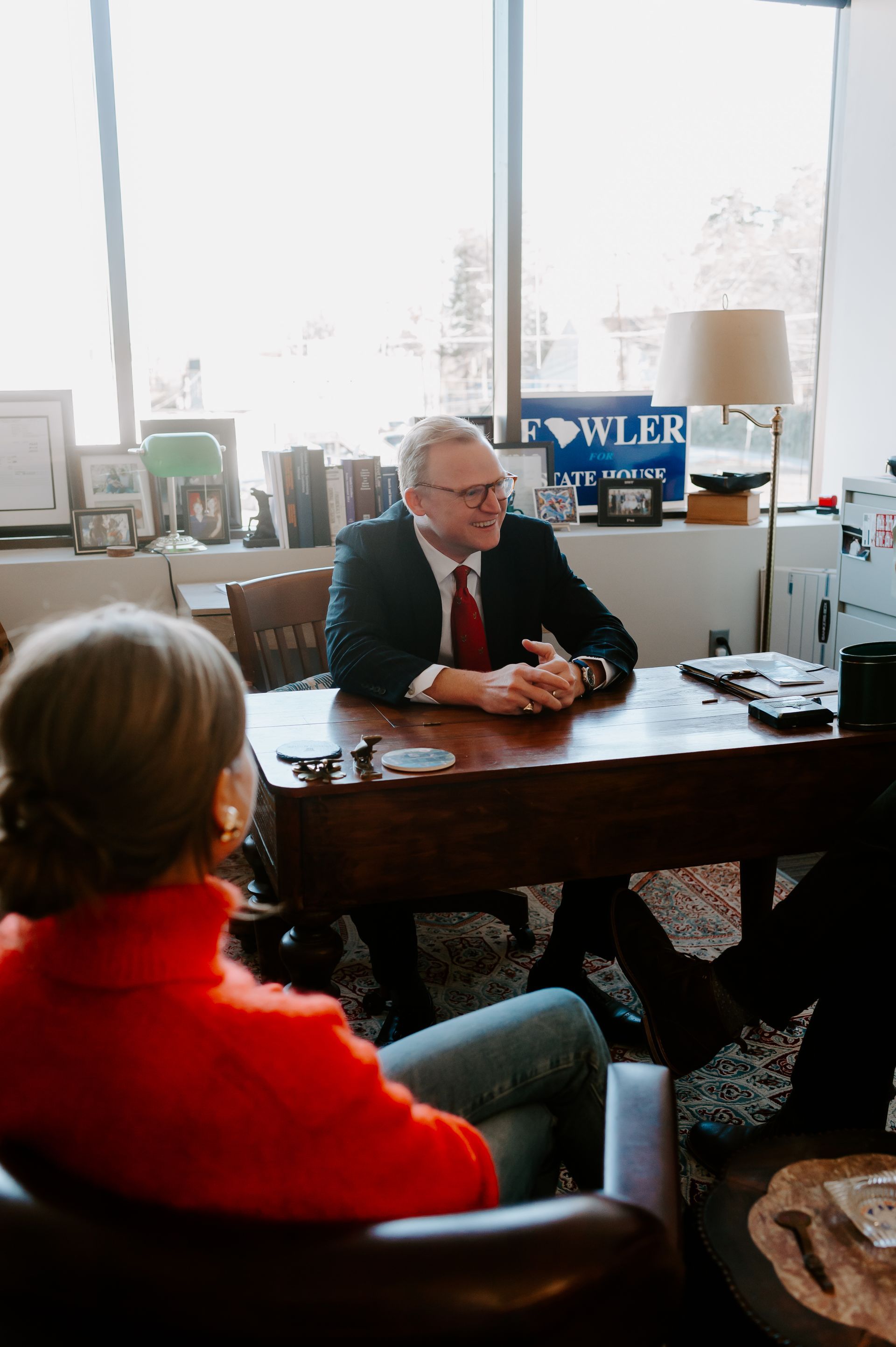 Brann Fowler seated at a desk in his office speaking during a meeting
