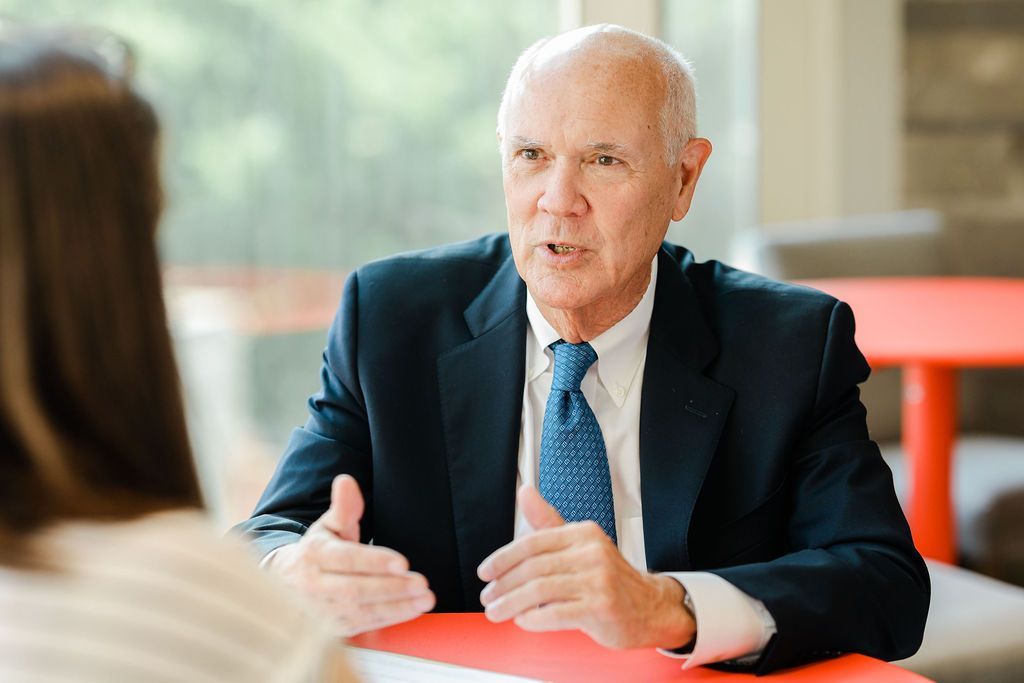 Joe Watson in a suit speaking during a meeting