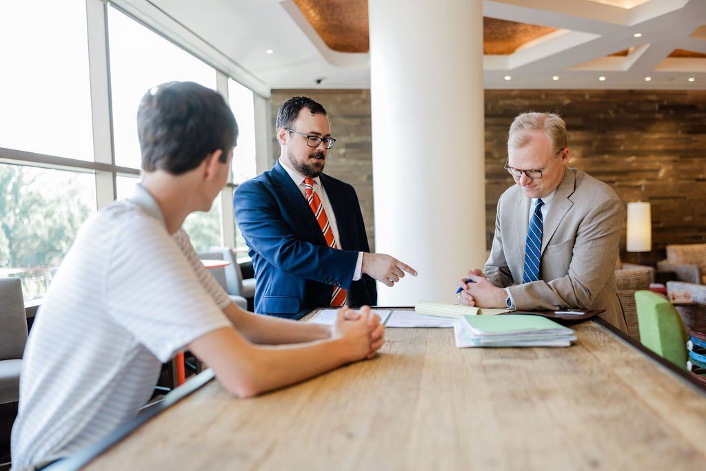 Attorneys reviewing legal documents with a client during a consultation
